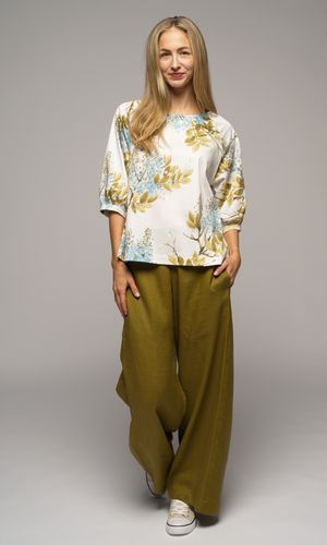 Woman wearing a floral blouse and wide-leg olive green pants.