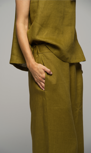 Women wearing olive green pants and singlet top, closeup of the pocket detail of the pants.