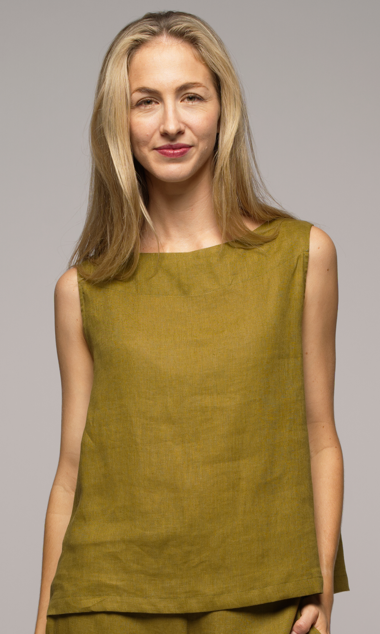 Close up of a woman wearing a olive green singlet top.