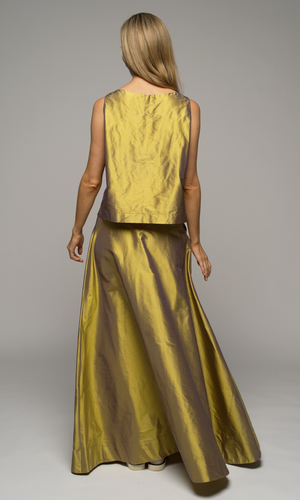 Woman wearing a gold silk sleeveless top with matching gold silk floor length flowing skirt, showing back of garments.