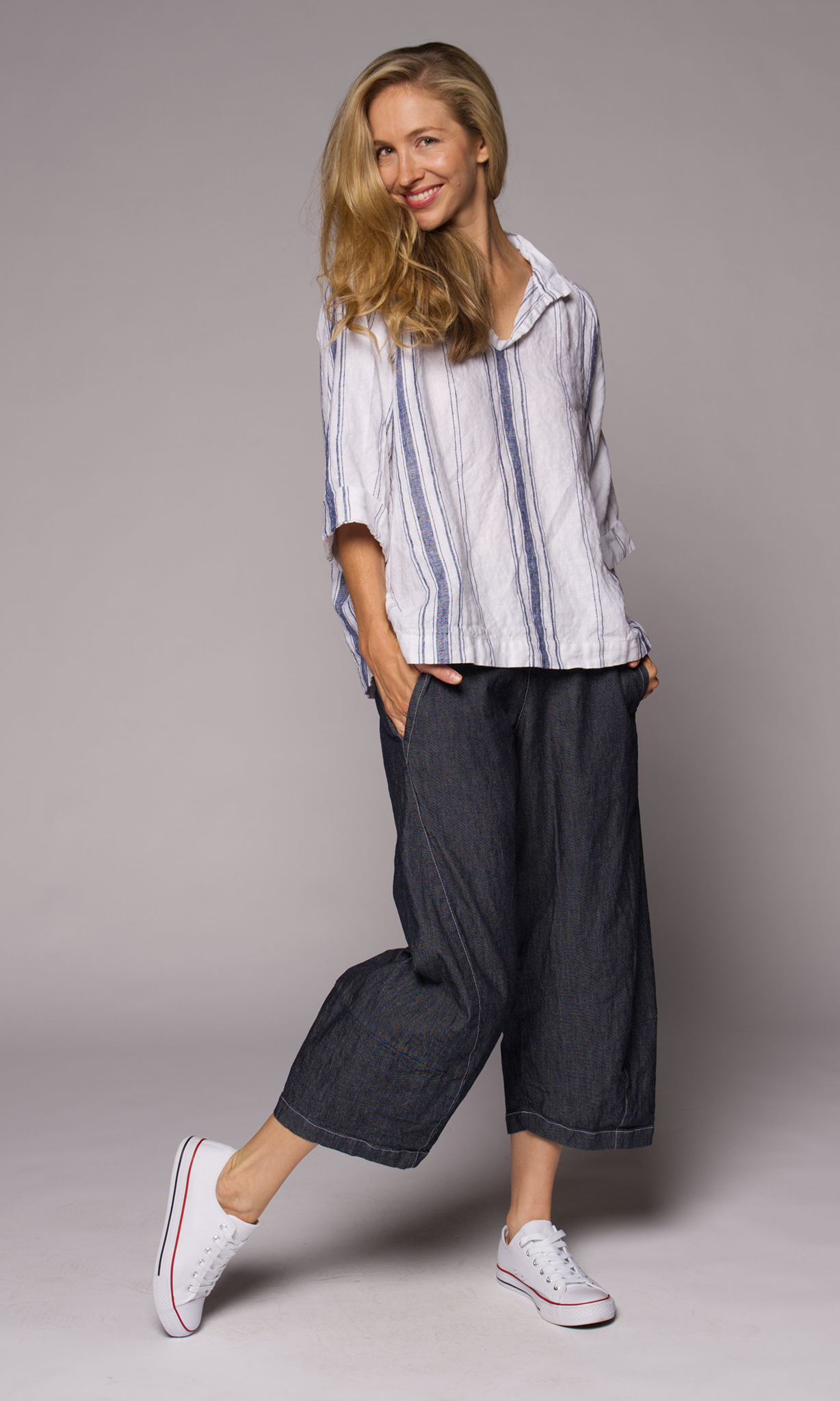 Blonde women wearing a collared top with denim pants.