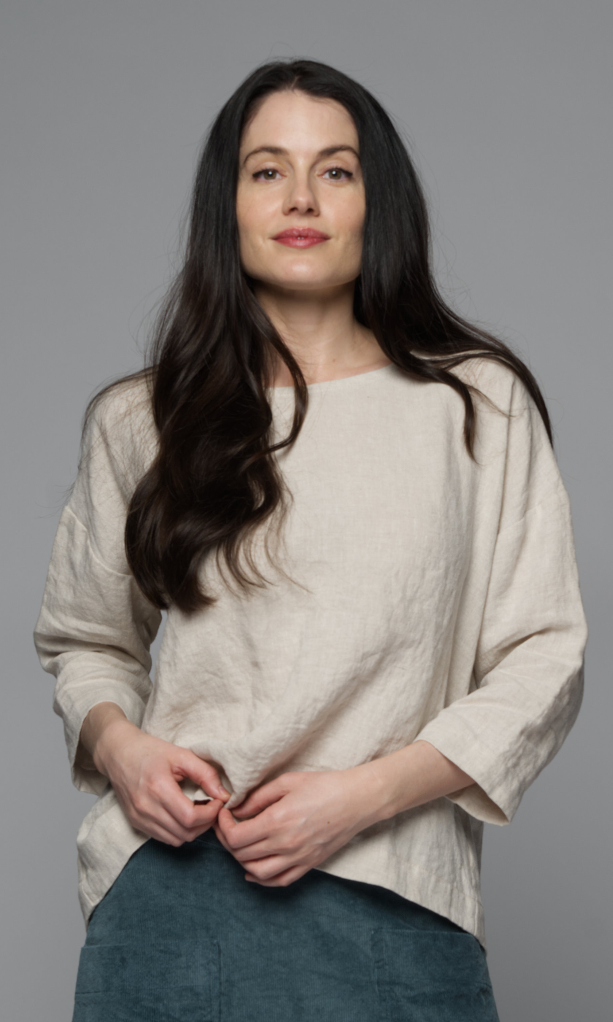A woman wearing a beige top.