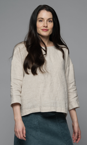 A woman wearing a beige top.