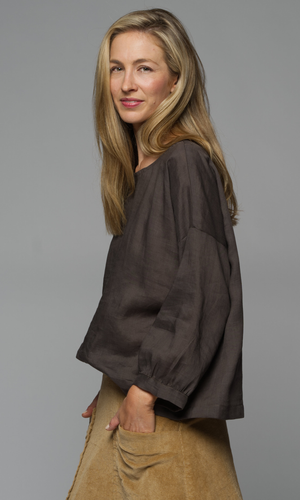A woman wearing a brown blouse.