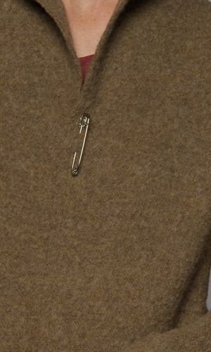 A close up of the jacket's neckline with a pin closure.