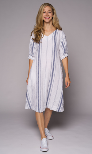 Blonde haired woman modelling a long striped linen dress.