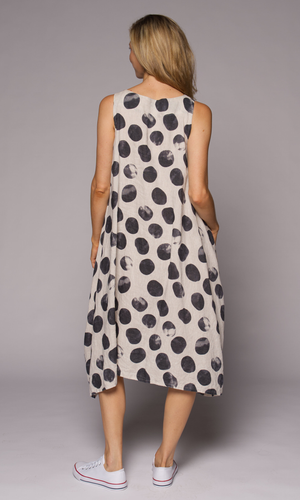 Blonde woman modelling cream coloured dress with charcoal dots, showing us the back.