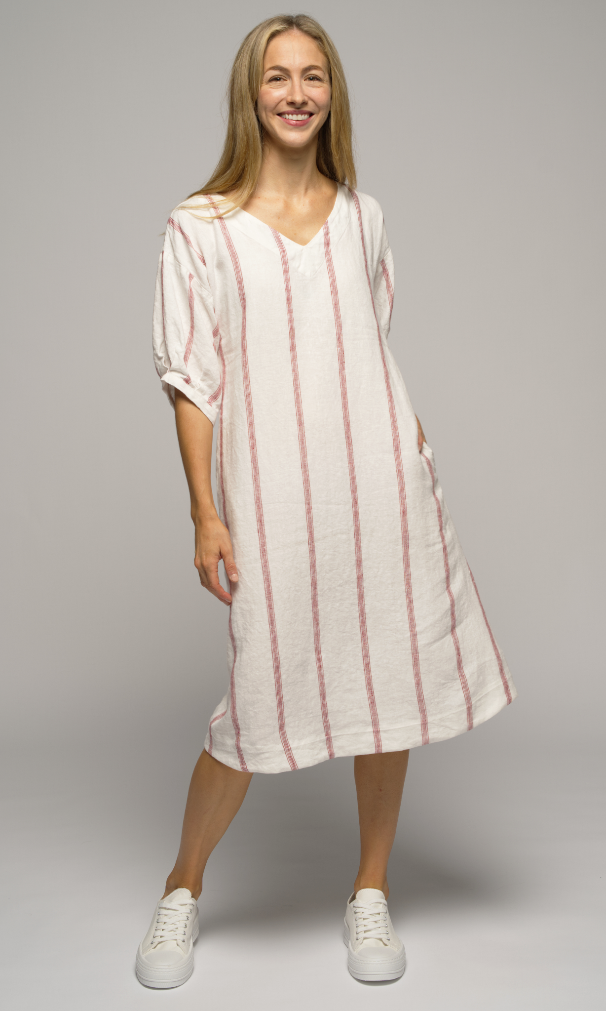 Woman wearing a white dress with red stripes.