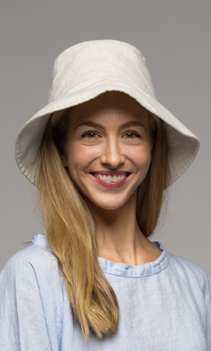 Woman with blonde wearing a light-colored bucket hat.