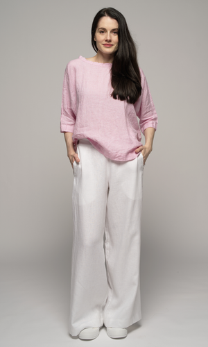 Woman wearing a pink top and white pants.
