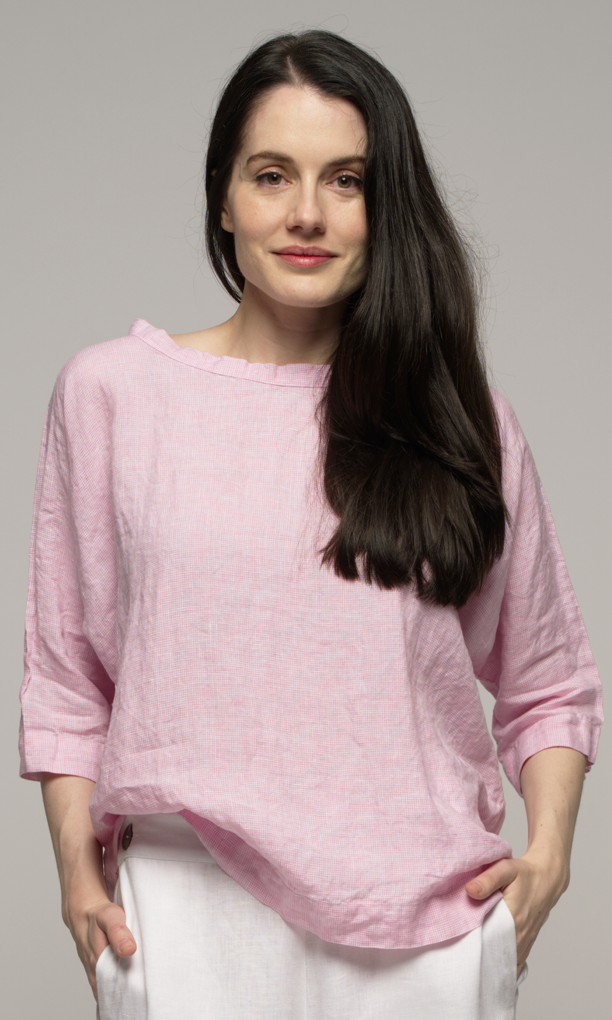 A close up of a woman wearing a pink top.