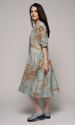 Woman wearing a light blue floral dress, facing left.