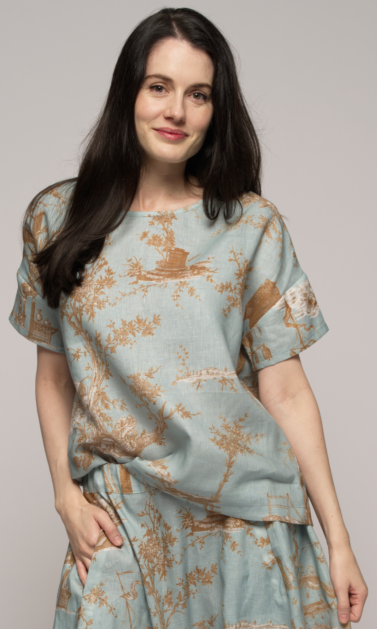 Close up of a woman wearing a light blue floral top.