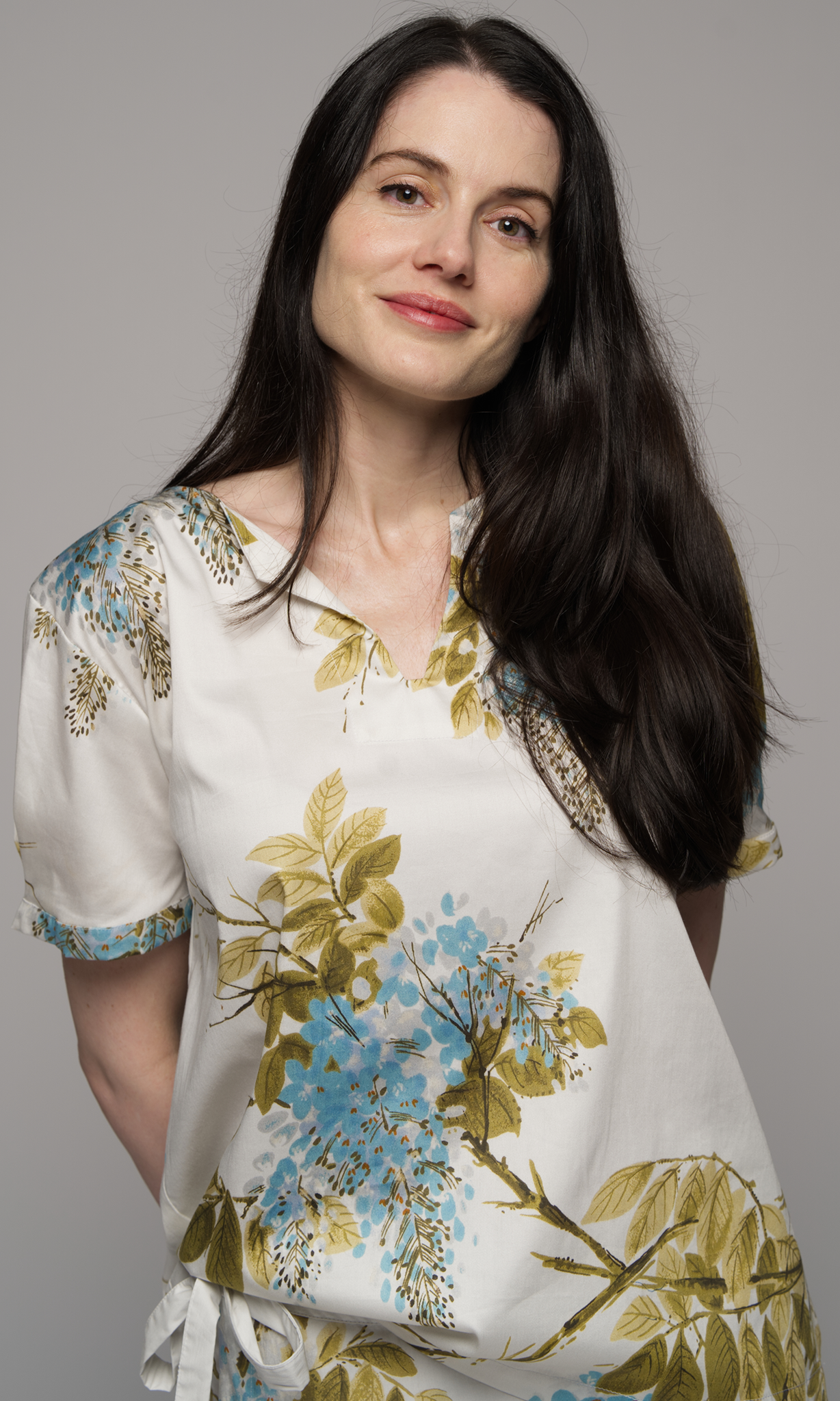 Woman wearing a floral short sleeve top and a floral skirt, showing close up of the top.